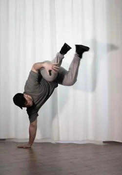 Dance in motion, pose of a man in hip-hop style clothes. Sports dancing guy.. Stock Photos