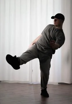 Dance in motion, pose of a man in hip-hop style clothes. Sports dancing guy.. Stock Photos