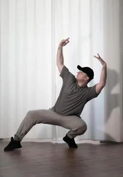Dance in motion, pose of a man in hip-hop style clothes. Sports dancing guy.. Stock Photos