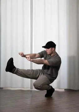 Dance in motion, pose of a man in hip-hop style clothes. Sports dancing guy.. Stock Photos