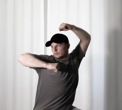 Dance in motion, pose of a man in hip-hop style clothes. Sports dancing guy.. Stock Photos