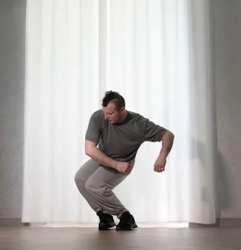 Dance in motion, pose of a man in hip-hop style clothes. Sports dancing guy.. Stock Photos