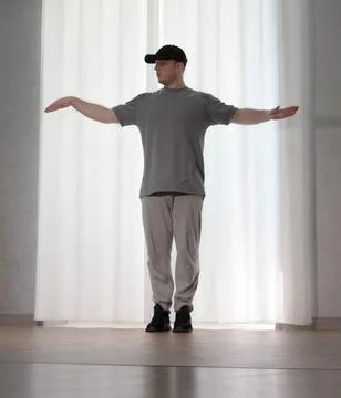 Dance in motion, pose of a man in hip-hop style clothes. Sports dancing guy.. Stock Photos