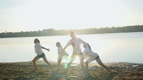 Dance performance of four girls on sand beach near lake at dawn 動画素材 65294361