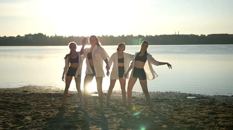 Dance performance of four girls on sand beach near lake at dawn Stock Footage 65294583
