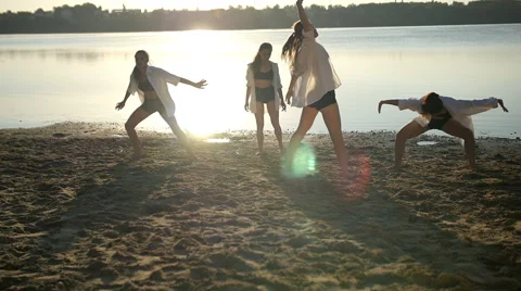 Dance performance of four girls on sand beach near lake at dawn Stock Footage 65295265