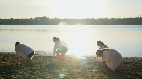 Dance performance of four girls on sand beach near lake at dawn Stock Footage 65295568