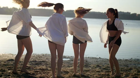 Dance performance of four girls on sand beach near lake at dawn Stock Footage 65297829