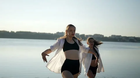 Dance performance of four girls on sand beach near lake at dawn Stock Footage 65298002