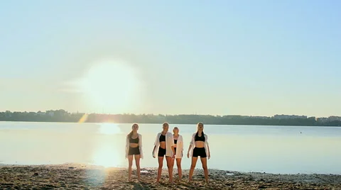 Dance performance of four girls on sand beach near lake at dawn Stock Footage 65320602