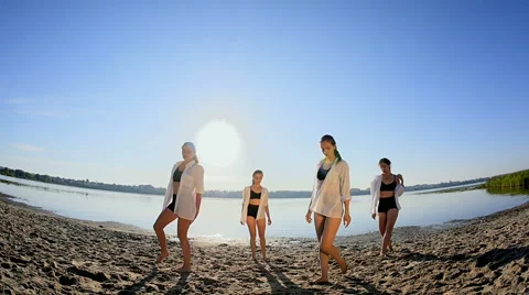 Dance performance of four girls on sand beach near lake at dawn Stock Footage 65321449