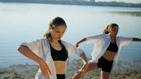Dance performance of four girls on sand beach near lake at dawn Stock Footage 69227391