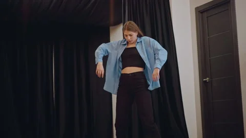 Dance practice session. Contemporary female dancer practices alone with coaching Stock Footage 346552582