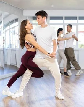 Dance studio - students in casual clothes learn to dance tango Stock Photos