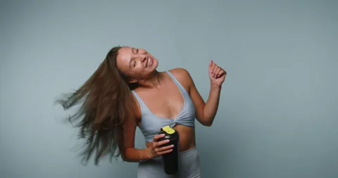 Dance workout with water bottle in bright studio setting showing fun moveme.. Vidéo 331990167