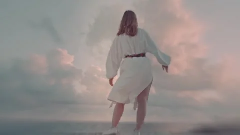 A dance of a young woman in the wind under an endless sky Stock Footage 346719049