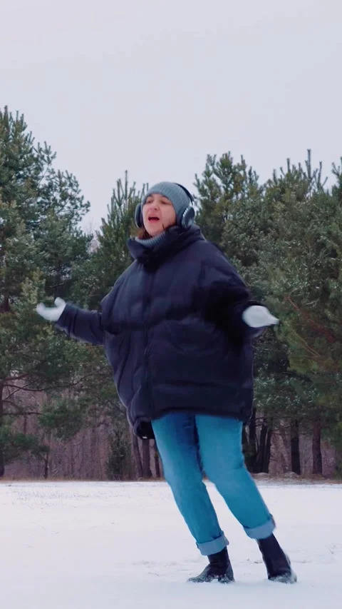 Dancer amidst snow, Young woman with bright expression dances in winter clearing Stock Footage 325205193