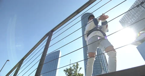 A dancer in a baseball cap and high boots is dancing on the street Видео 146837992