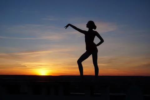Dancer in the dance does the splits in the air against the sunset Stock Photos