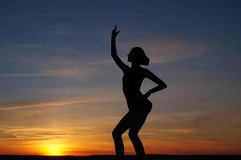 Dancer in the dance does the splits in the air against the sunset. Stock Photos