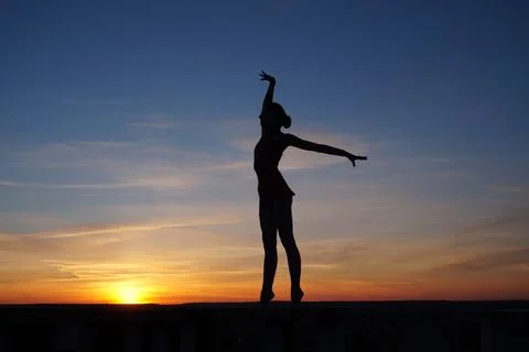 Dancer in the dance does the splits in the air against the sunset Stock Photos