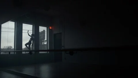 Dancer dances in front of large window in silhouette in a dance studio Vídeos de archivo 104274448
