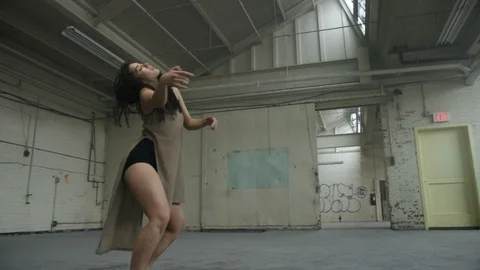 Dancer dances in industrial warehouse filled with fog, dropping to the ground Vídeos de archivo 104474355