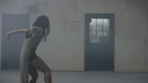 Dancer dances in slow motion surrounded by fog in warehouse Vidéo 104477546