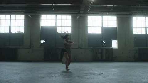 Dancer dancing in industrial warehouse with lots of energy and passion Stock Footage 104463559