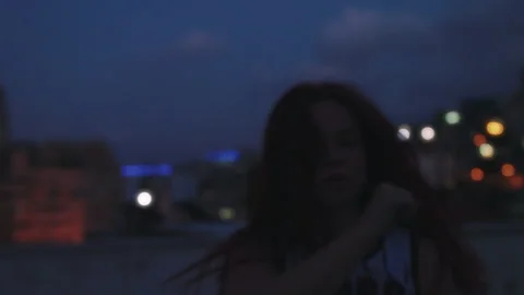 Dancer dancing on rooftop overlooking city lights at sunset Stock Footage 275098685