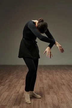 The dancer gracefully arched her back and crossed her arms with her head bowed Stock Photos