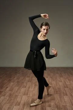 The dancer gracefully struck a pose with her arms above her head Stock Photos