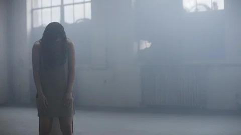 Dancer with head down slowly begins to move surrounded by fog 스톡 동영상 104478354