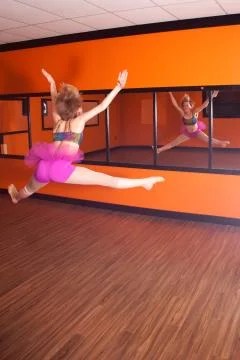Dancer jumping in front of mirror Stock Photos
