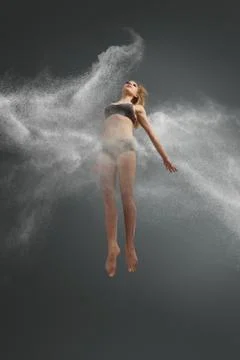Dancer jumping into white powder cloud Stock Photos