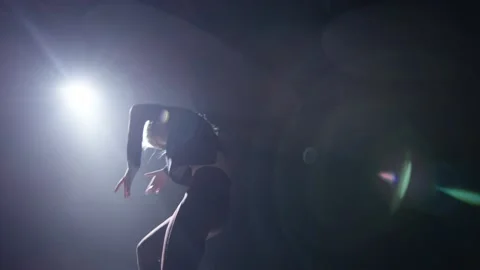 A dancer makes movements of bird and angel in the dark Stock Footage 210547792