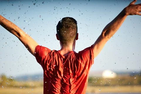 Dancer man with his back wet in a lake with a red shirt. Stock Photos