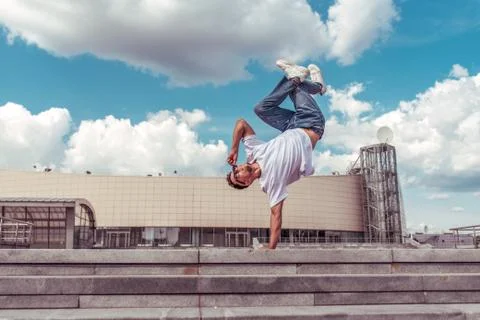 Dancer on one arm dances break dance, hip-hop, artist acrobat. Summer city Stock-Fotos