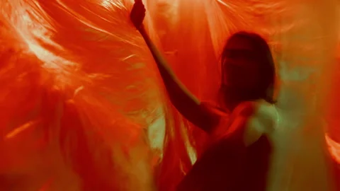 Dancer Performing Fluid Movements in Flowing Colorfully-Lit Plastic Curtains Stock Footage 289822758