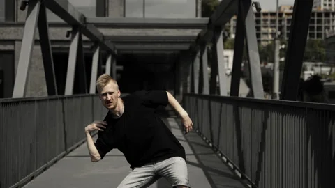 A dancer performs an active dance in the city against the backdrop of tall Stock Footage 252070260