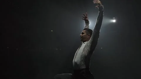 Dancer performs Broken Spanish Turn in ray of light, bending at small of back Stock Footage 275034619