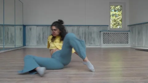 Dancer performs a dance, rolling and sliding her whole body on the floor. Stock Footage 287099634