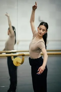 Dancer performs graceful movements in a studio with mirrors during a dance Stock Photos