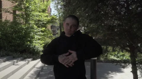 A dancer performs a light-hearted freestyle hip-hop routine on a city sidewalk. Stock Footage 283489669