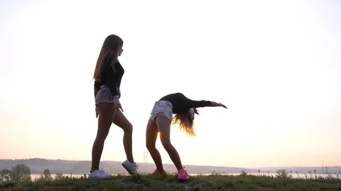 Dancer pose and one legged handstand performed by two women, 4k Stock Footage 111629403