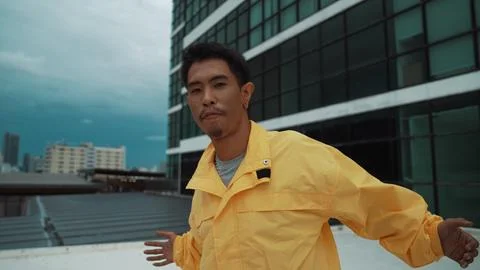 Dancer pose at camera while standing at rooftop. Low angle camera. Endeavor. 写真素材