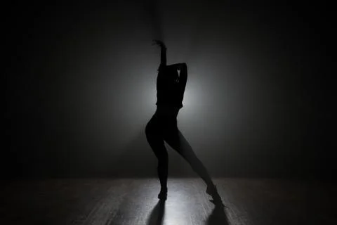 Dancer posing in the dark and smoke Stock Photos