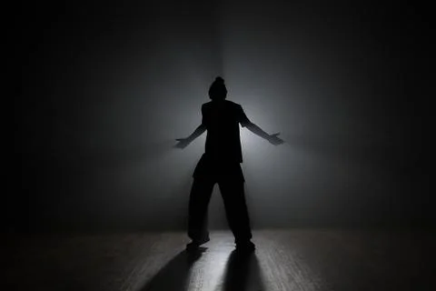 Dancer posing in the dark and smoke Stock Photos