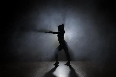 Dancer posing in the dark and smoke Stock Photos