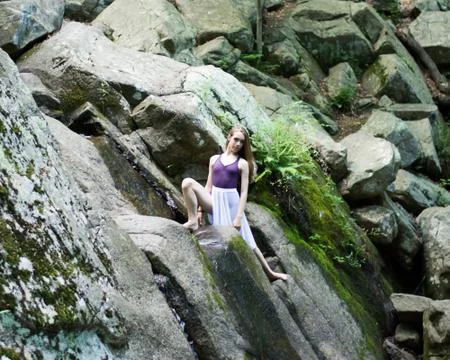 Dancer posing on a waterfall Stock Photos